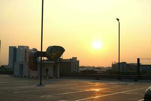 pôr do sol cenas em a telhado carro parque e dourado céu foto