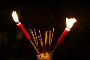 queimando incenso e vermelho velas para pagar homenagem em uma Sombrio fundo durante com fome fantasma festival pagar homenagem para seus falecido ancestrais foto