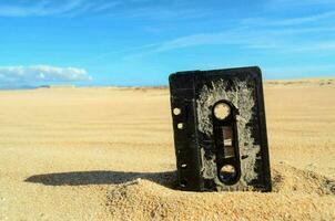 velho cassete fita em a areia foto