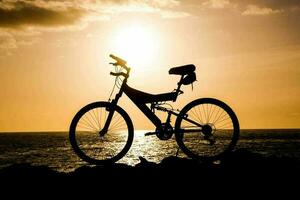 montanha bicicleta sobre a pôr do sol foto