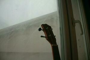 ukulele guitarra inclinado contra janela Como isto termina jogando, pode 7, 2023 Peru foto