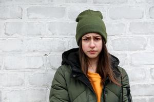 retrato de uma linda garota triste com um suéter amarelo e um chapéu cáqui