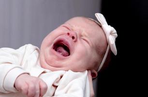 bebê de um mês de idade grita e chora na mãe foto