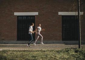 jovem casal correndo no ambiente urbano foto