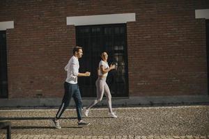 jovem casal correndo no ambiente urbano foto