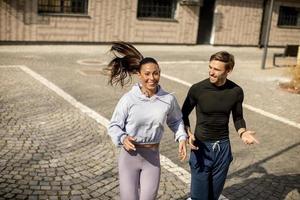 jovem casal de fitness correndo em área urbana foto