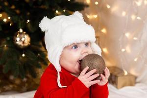 bebê segura bola de natal foto