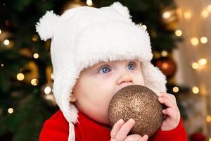 bebê segura bola de natal foto