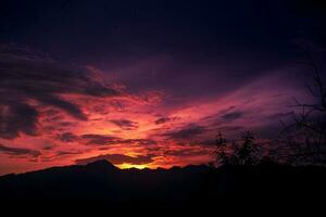 lindo pôr do sol céu com montanha silhueta foto