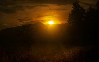 pitoresco dourado hora pôr do sol com montanha foto