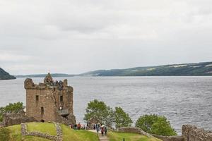 pessoas no castelo urquhart na costa do lago ness, na Escócia foto