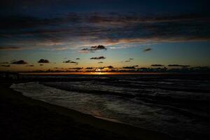 pitoresco calma pôr do sol com colorida nuvens em a margens do a báltico mar dentro Polônia foto