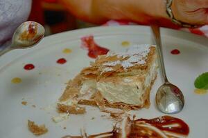 doce calórico papal fundente servido com em branco prato com fruta com uma prata aço colher foto