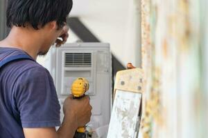 reparador fixação ar condicionador unidade, técnico homem instalando a ar condicionamento dentro uma cliente casa, manutenção e reparação conceitos foto