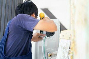 reparador fixação ar condicionador unidade, técnico homem instalando a ar condicionamento dentro uma cliente casa, manutenção e reparação conceitos foto