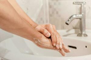 fechar-se do homem lavando dele mãos dentro a banheiro. higiene conceito para prevenção cobiçado - 19. foto