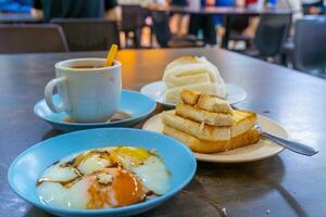tradicional café da manhã conjunto e café, fervido ovos e brinde, popular dentro Cingapura foto