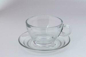 esvaziar transparente vidro Vejo através café chá copo pires em branco fundo foto