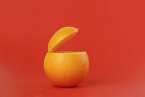saudável laranja cortar flutuando topo fatia suco beber idéia conceito em vermelho fundo foto
