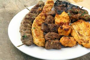 misturado carvão grelhado prato frango carne Carneiro bode carne shish Kebab tawook meio leste árabe de madeira mesa foto