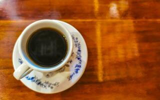 pote de xícara branca azul com mesa de madeira de café preto méxico. foto