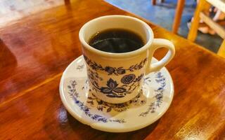 pote de xícara branca azul com mesa de madeira de café preto méxico. foto