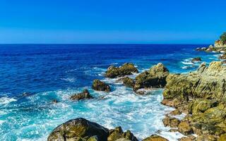 surfista ondas turquesa azul água pedras falésias pedregulhos porto escondido. foto