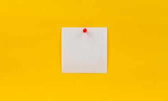 nota de papel em branco vazia fixada em alfinete vermelho em um fundo amarelo foto