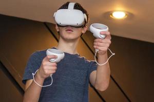 menino jogando jogos de realidade virtual com fone de ouvido foto