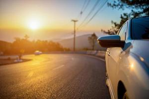 carro para viajar em uma estrada de montanha com o nascer do sol da manhã ao fundo foto