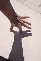 mão gesticulando nas sombras foto