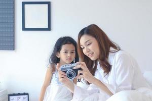 mãe e filha olhando lindas fotos da câmera