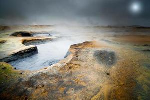 piscina de lama quente e fervente na paisagem dramática de hverir iceland com lua cheia foto