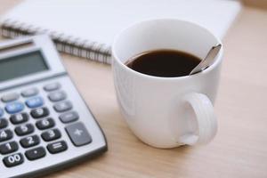 uma xícara de café preto na mesa de trabalho foto