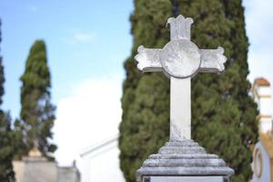 cruz de mármore branco em um cemitério foto