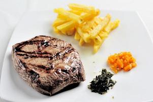 carnes grelhadas e batatas fritas acompanhadas de molho chimichurri foto