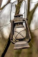 velha lâmpada de querosene enferrujada pendurada em um galho