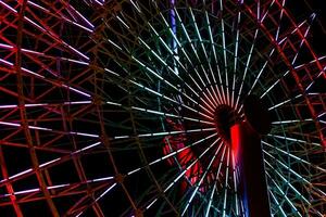 colorida luz fluorescente em estrutura do ferris roda com Sombrio noite fundo. foto