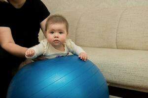 mãe faz ginástica com dela bebê em uma fitball foto