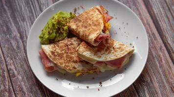 uma prato do Comida com uma Quesadilla e guacamole em isto. foto