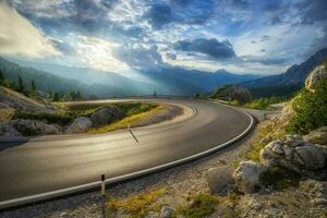 montanha estrada às colorida pôr do sol dentro verão. curvado estrada foto