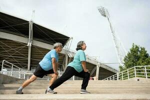 ásia Senior casais vestem Esportes equipamento e aquecimento acima músculos antes exercício às ao ar livre dentro a manhã. feliz idosos ao ar livre estilo de vida conceito, cheio comprimento do ativo feliz idosos família casal foto