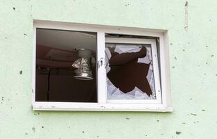 destruído e estragado janela dentro a construção Como uma resultado do a guerra. a casas estavam destruído e queimado de artilharia durante a guerra. quebrado janelas. uma janela destruído de a brigando. foto