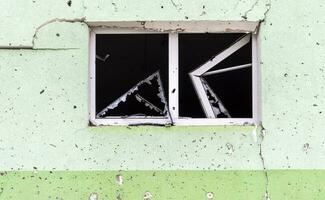 destruído e estragado janela dentro a construção Como uma resultado do a guerra. a casas estavam destruído e queimado de artilharia durante a guerra. quebrado janelas. uma janela destruído de a brigando. foto