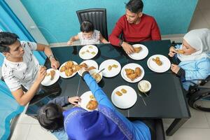 grupo do sudeste ásia adulto criança menina masculino fêmea comendo almoço às jantar mesa disparamos frango. elas estão autista baixa síndrome adhd paralisado cadeira de rodas foto