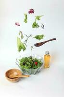 misturar frondoso vegetal salada verde roxa alface vidro tigela elevado vôo caindo foto
