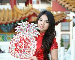 jovem sul leste ásia chinês homem mulher tradicional traje chinês Novo ano cumprimento ao ar livre às têmpora foto