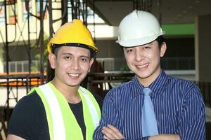 sul leste ásia jovem malaio chinês homem mulher vestindo em segurança capacete construção local trabalhos foto