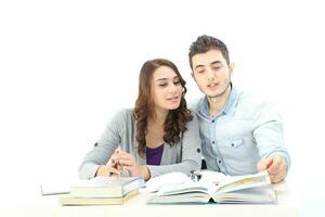 Yong sul leste ásia meio Oriental caucasiano juventude homem mulher dentro casual vestir andar conversa Diversão sentar às mesa livro caderno caneta computador portátil computador estude pensar ler em branco fundo foto