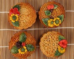 colorida flor decorado mooncake chinês meio outono festival em bambu Comida esteira fundo foto